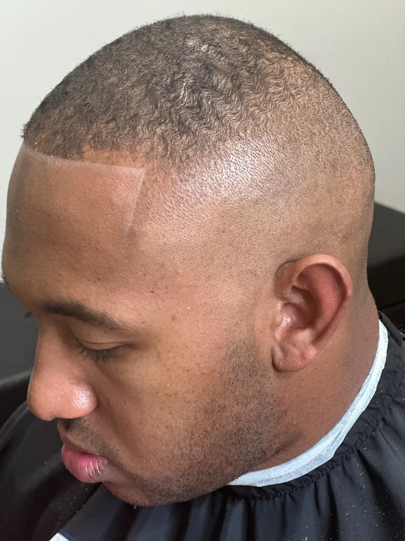A high skin fade with a crisp lineup and temple detail, by Clifton Al-Hakeem in Owings Mills