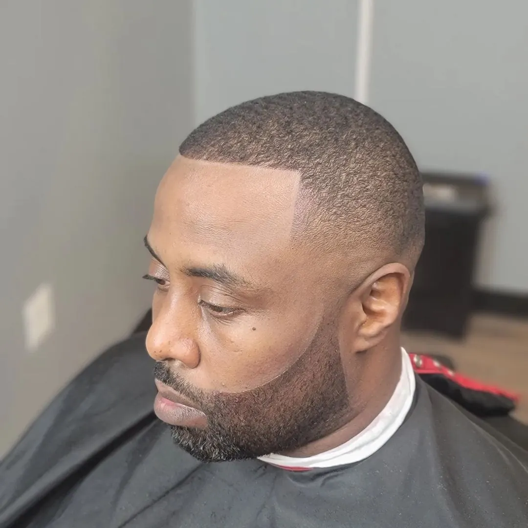 A low fade with 360 waves, a sharp lineup, and a connected beard, by Clifton Al-Hakeem in Owings Mills