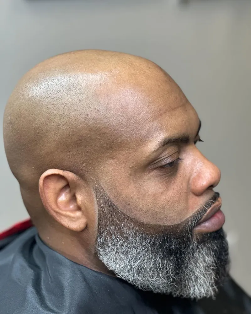 Clean head with a sculpted gray beard by Clifton Bey at Al-Hakeem's Tonsorial