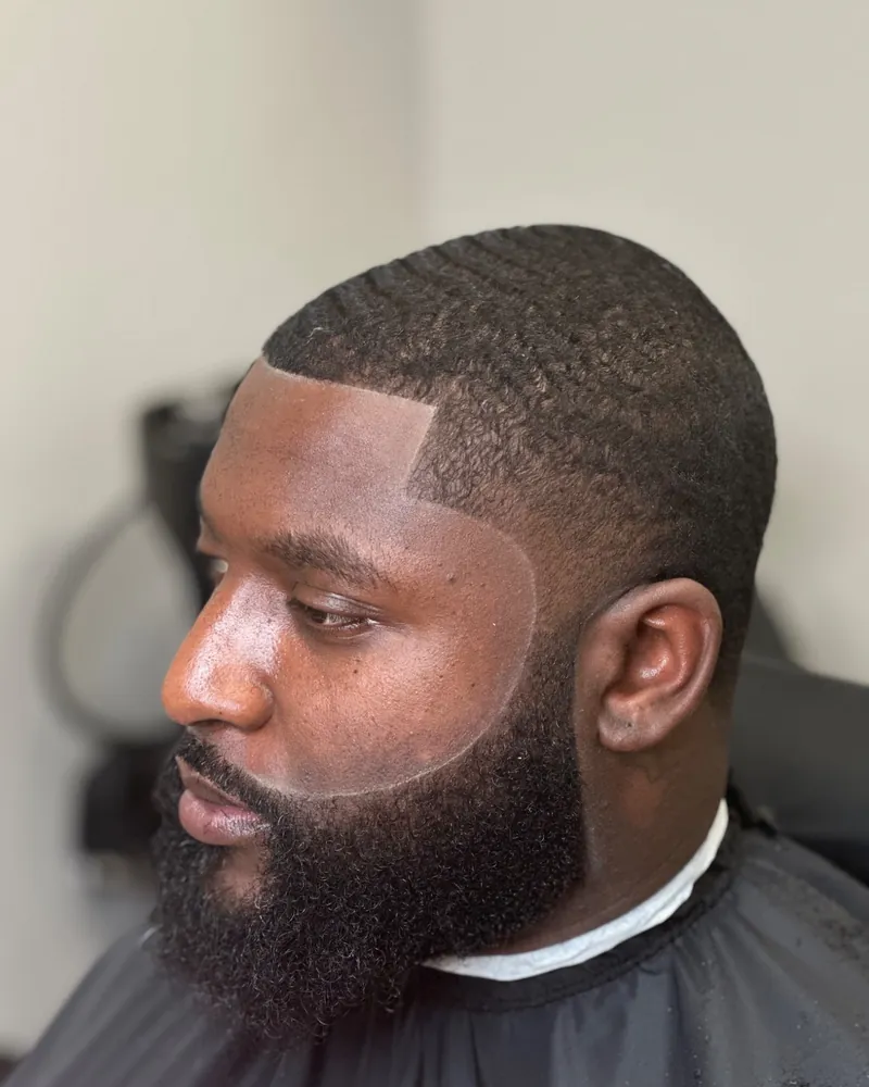 Low fade with a sharp lineup and a full beard by Clifton Bey at Al-Hakeem's Tonsorial